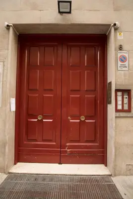 a red door on the side of a building at G&M Place in Palermo
