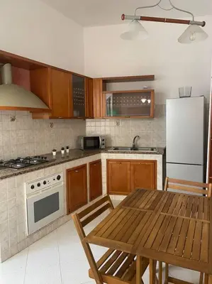 a kitchen with a wooden table and a white refrigerator at Casa Visconti 170mq-centro storico in Palermo