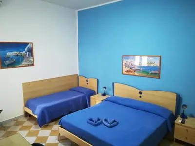 two beds in a room with blue walls at Appartamento Mediterraneo Mondello in Palermo