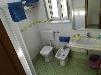 a bathroom with a toilet and a sink at Appartamento Mediterraneo Mondello in Palermo