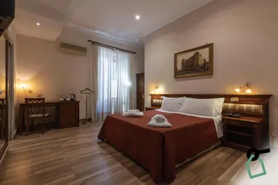 a bedroom with a bed and a desk and a window at HOTIDAY Room Collection - Palermo Politeama in Palermo