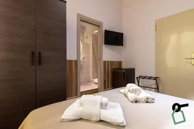 a bedroom with a bed with towels on it at HOTIDAY Room Collection - Palermo Politeama in Palermo