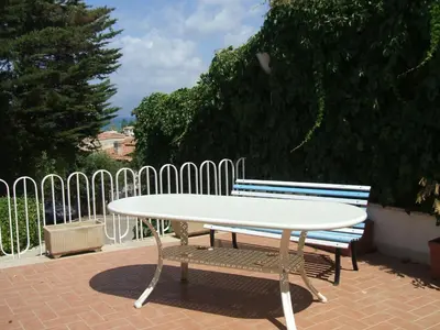 a white table and bench next to a fence at Villa Aliotis in Alcamo Marina