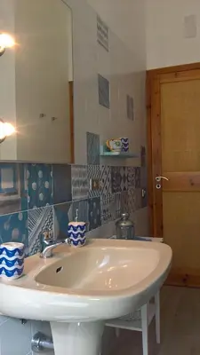 a bathroom with a white sink and a mirror at Villa Aliotis in Alcamo Marina