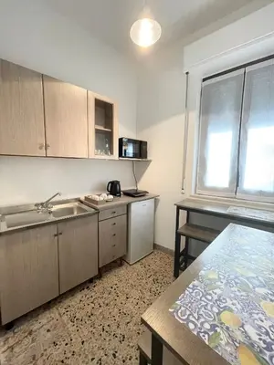 a small kitchen with a sink and a table at ViLoKa Sicilian Guest House in Calatafimi