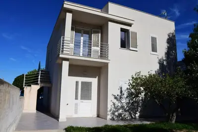 a white house with a porch and a balcony at Villa Luxury Fronte mare San Vito lo Capo in San Vito lo Capo