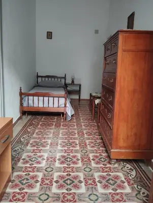 a bedroom with a bed and a dresser at Casa Gerani in Castellammare del Golfo