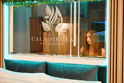 a window of a restaurant with a woman in it at Cala Sikula Suite &SPA in Palermo