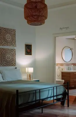 a bedroom with a bed and a bathroom with a sink at Croce Barocca Apartment in Palermo
