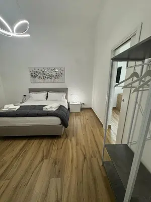 a bedroom with a bed and a wooden floor at Mortillaro 19 in Palermo