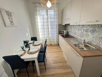 a kitchen with a table with chairs and a sink at Mortillaro 19 in Palermo