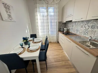 a white kitchen with a table and chairs and a sink at Mortillaro 19 in Palermo