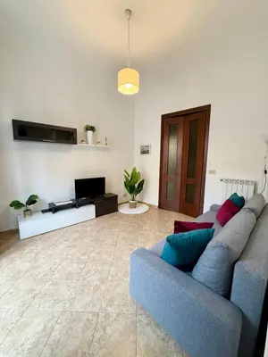 a living room with a blue couch and a tv at Gigi's Apartment in Palermo