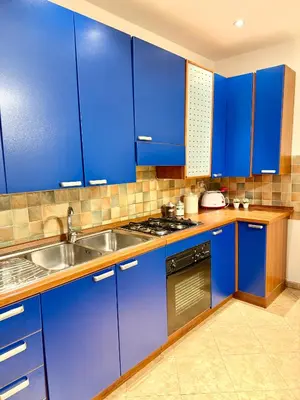 a kitchen with blue cabinets and a sink at Gigi's Apartment in Palermo