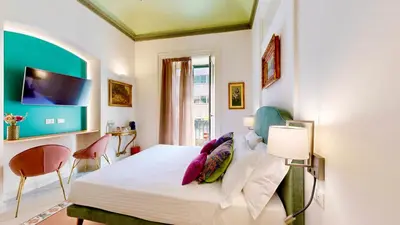a bedroom with a bed and a tv on the wall at Palazzo Genuardi - charming rooms - in Palermo