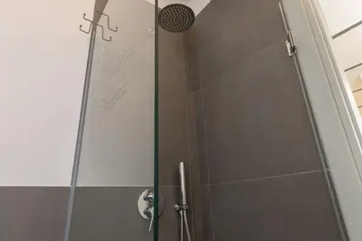 a shower with a glass door in a bathroom at Politeama Luxury Suite in Palermo