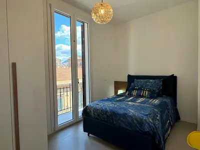 a bedroom with a bed and a large window at Politeama Libertà Home Sweet Home in Palermo