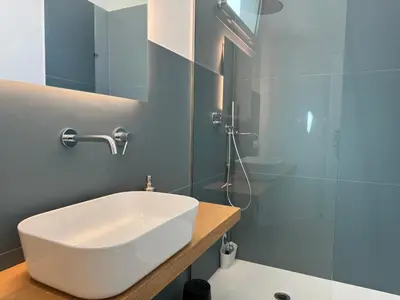 a bathroom with a white sink and a shower at Politeama Libertà Home Sweet Home in Palermo
