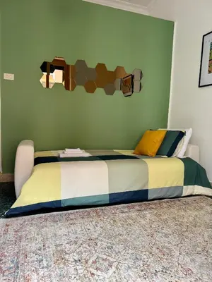 a bed in a bedroom with a green wall at Quattru Passi in Palermo