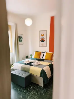 a bedroom with a bed with orange and green sheets at Quattru Passi in Palermo