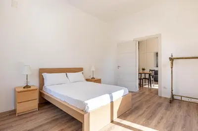 a bedroom with a large bed and a table at Turati Apartment al Politeama by Wonderful Italy in Palermo