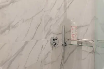 a shower with a glass door with a bottle of shampoo at Turati Apartment al Politeama by Wonderful Italy in Palermo