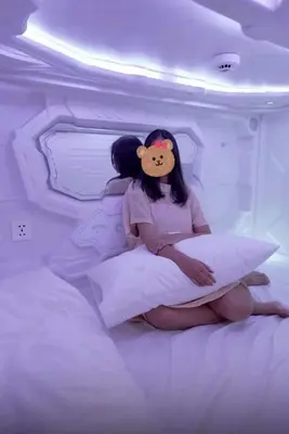 two girls sitting on a bed in a white room at Mermaid Space Capsule Hostel Palermo in Palermo