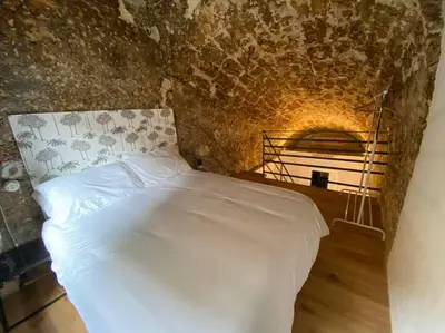 a bedroom with a white bed in a stone wall at Appartamento Centro Storico in Palermo