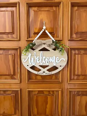 a welcome sign hanging on a wooden door at Casa MaRo' in Capaci