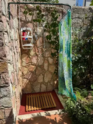 a wooden bench sitting next to a stone wall at Villa Mia in Carini