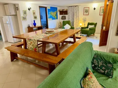 a living room with a table and a green couch at Villa Mia in Carini