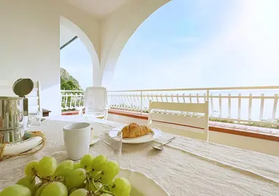a table with a plate of food on a balcony at Solemar Sicilia - Ville Paradiso in Santa Flavia