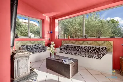 a living room with red walls and windows at Verosicily Panoramic House with access to the sea in Terrasini