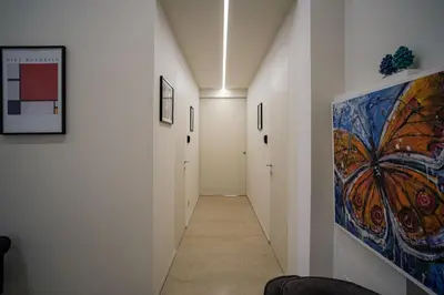 a hallway with white walls and a painting on the wall at Vissi d'Arte Rooms in Palermo