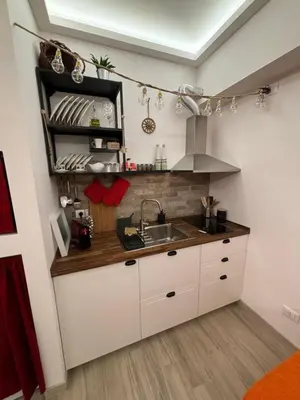 a kitchen with white cabinets and a sink at La Casa di Trudy in Palermo