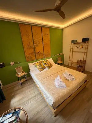 a bedroom with a bed with a green wall at La Casa di Trudy in Palermo