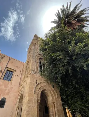 a church with a palm tree in front of a building at la fervoriana in Palermo