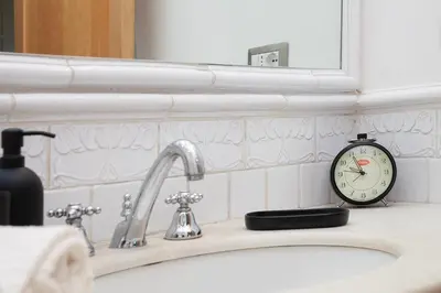 a bathroom sink with a clock on top of it at Casa Adele in Palermo
