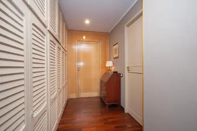 a hallway with white walls and wooden floors and a door at Casa Adele in Palermo