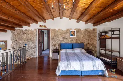 a bedroom with a bed and a stone wall at Verosicily Villa Glicine in Termini Imerese