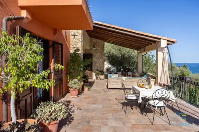 a patio with a table and chairs on a building at Verosicily Villa Glicine in Termini Imerese