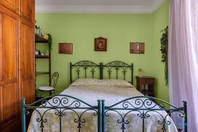 a bed in a bedroom with green walls at Verosicily Villa Glicine in Termini Imerese