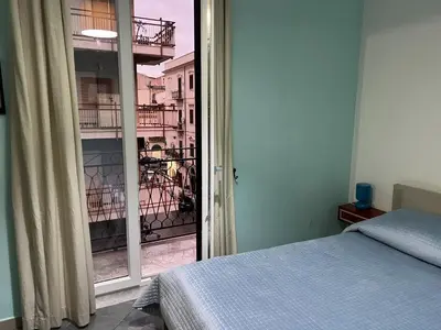 a bedroom with a bed and a view of a balcony at Le Stanze di Magritte in Palermo