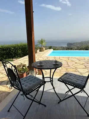 a patio with a table and two chairs next to a pool at Stella Del Mare in Scopello