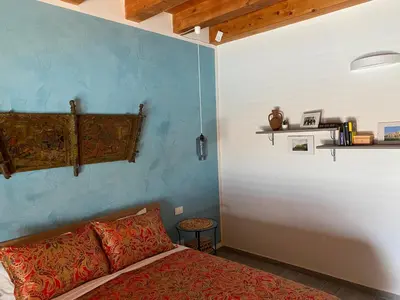 a bedroom with a bed and a blue wall at Stella Del Mare in Scopello