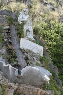 a statue of a woman sitting on the side of a hill at Locanda Del Drago in Monreale