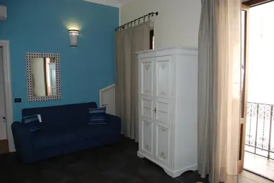 a blue living room with a blue couch and a mirror at Locanda Del Drago in Monreale