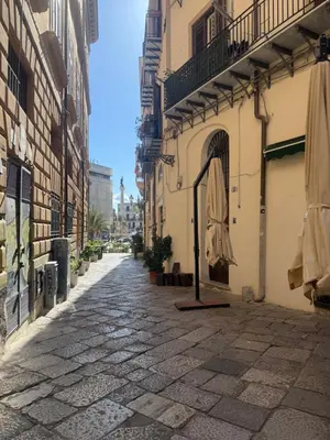 a bedroom with a bed with a chair and a window at monteleone centro apartment in Palermo