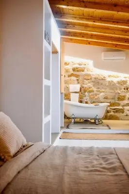 a bathroom with a bath tub in a stone wall at Duplex Townhouse with Gigantic Terrace in Palermo