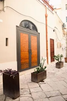a building with three potted plants in front of it at Duplex Townhouse with Gigantic Terrace in Palermo
